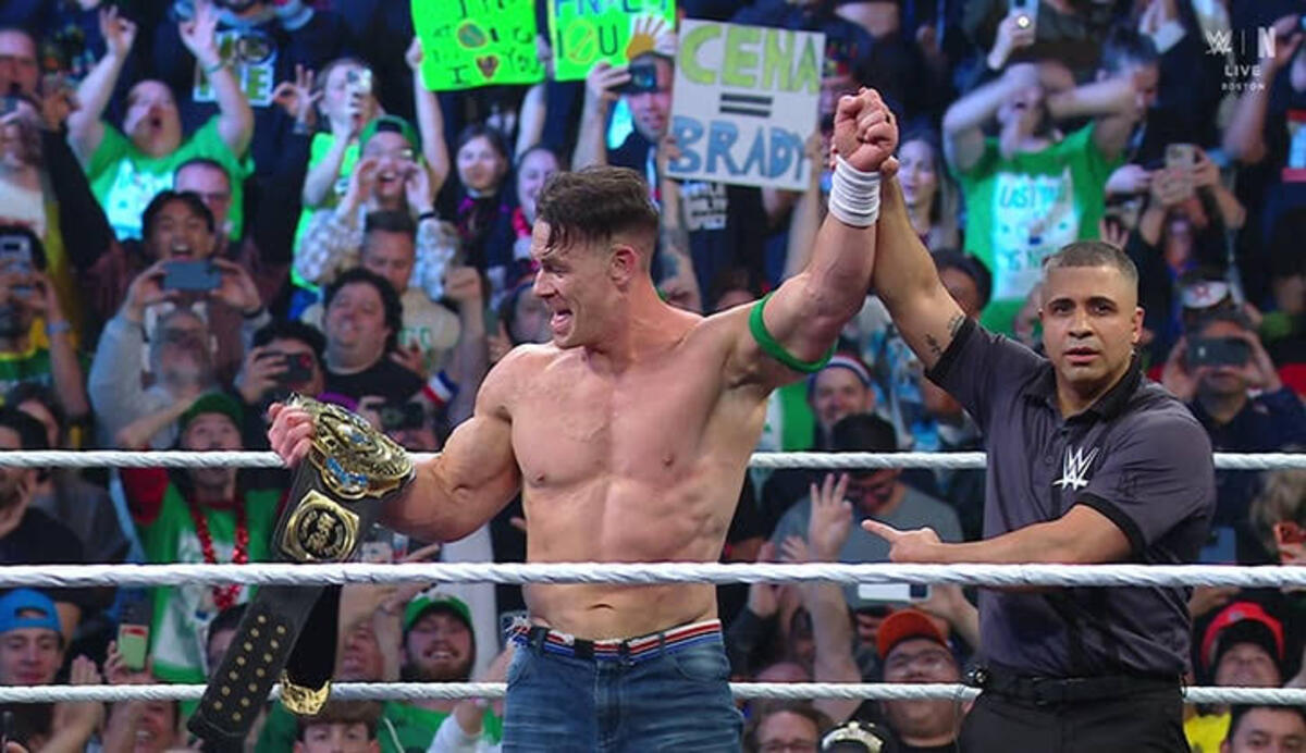 जॉन सीना आईसी चैंपियनशिप के साथ और रिया रिप्ली रिंग में दहाड़ते हुए।